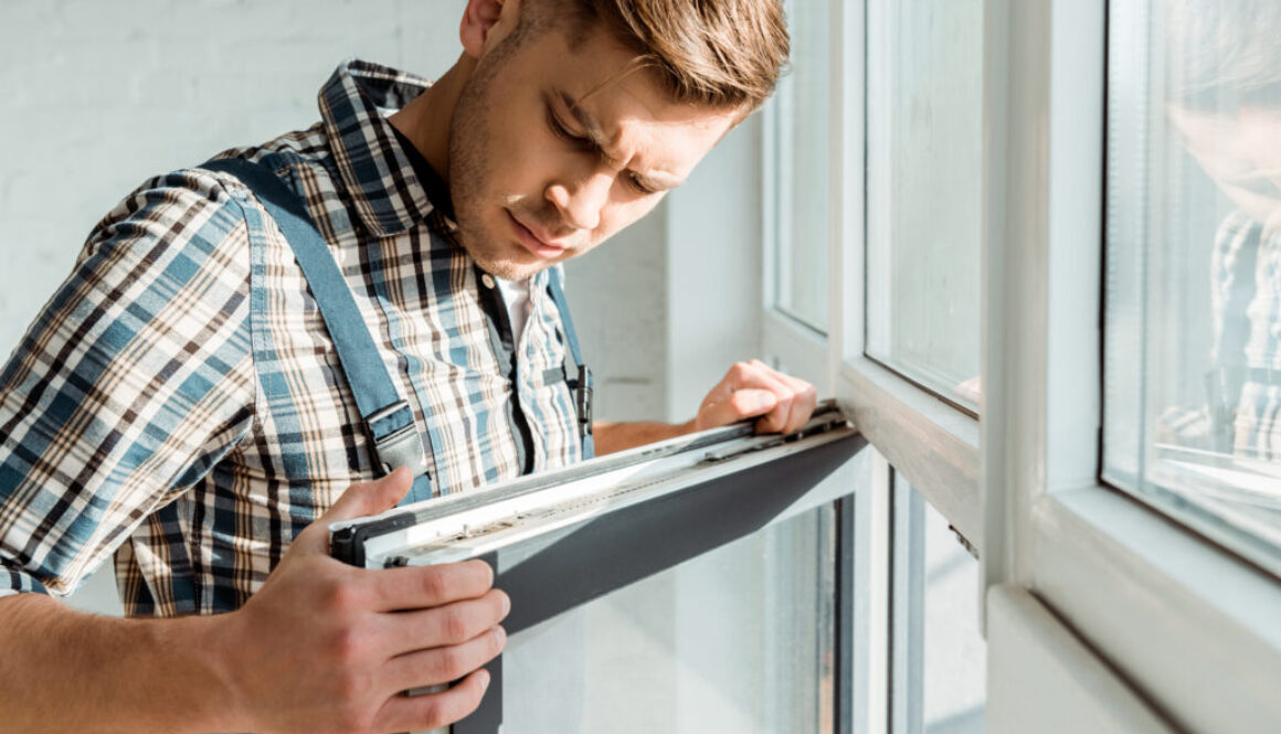 selective focus of handsome installer touching window